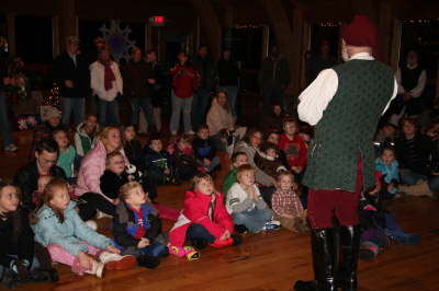 Santa telling a story to kids sitting on the floor at the Nature Center